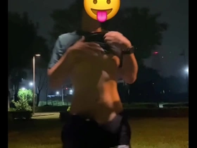 Solo Asian boy gets off on public bike ride in city park.