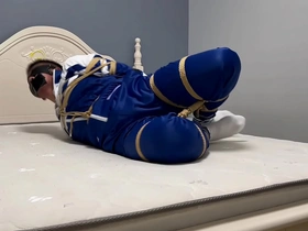 Young Asian man in hogtie bondage with ropes and shackles